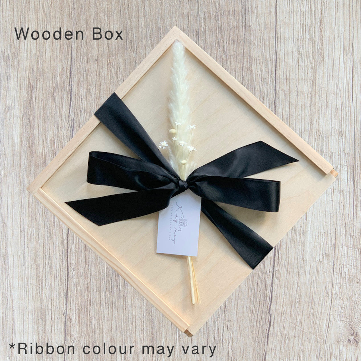 wooden gift box tied with a satin ribbon and dried pampas